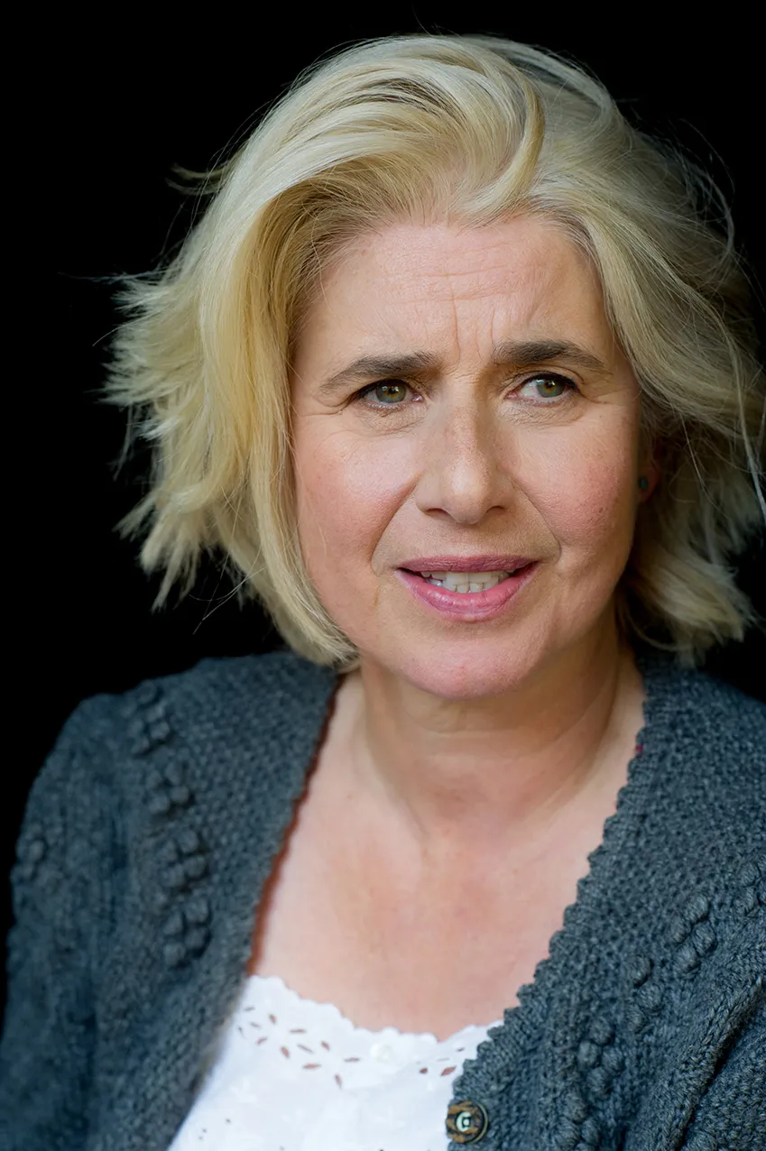 Angelika Fink in Nahaufnahme, graue Strickjacke, direkter Blick in die Kamera