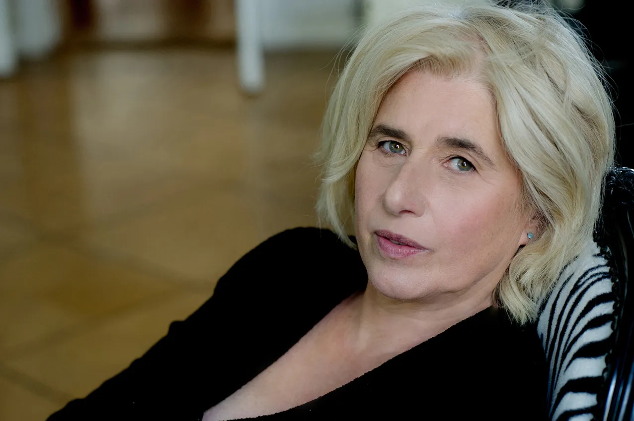 Angelika Fink in Schwarz, angelehnt, warmes Innenlicht