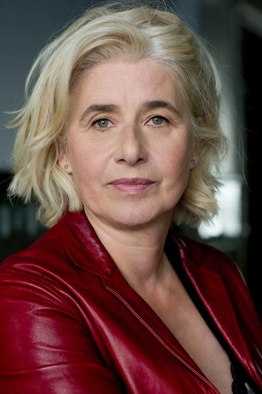 Angelika Fink in roter Lederjacke, Porträt vor dunklem Hintergrund